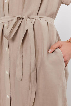 Close-up of the MARLA SILK COTTON VOILE DRESS by Velvet by Graham & Spencer, featuring buttons down the front, a tied belt at the waist, and a person’s hand in the side pocket.