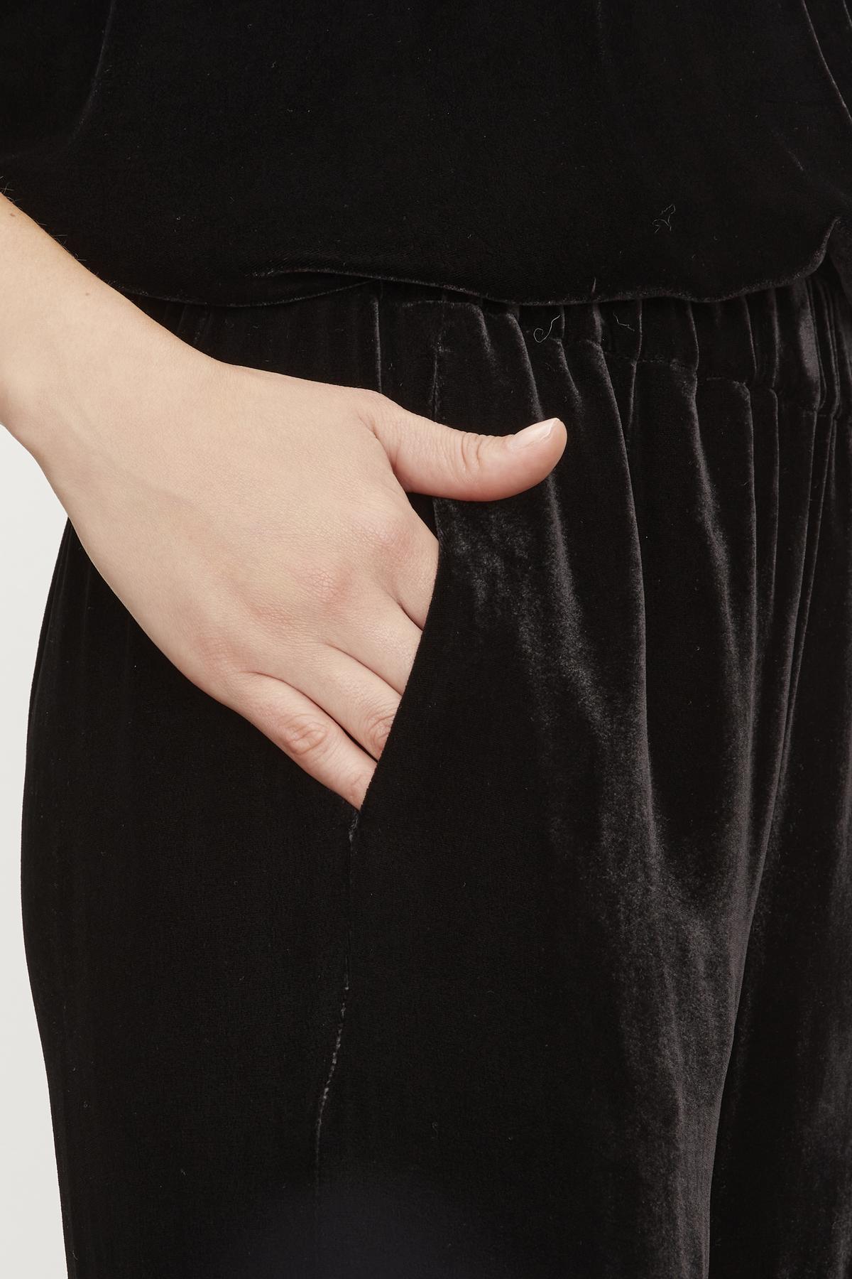  A close up of a woman wearing Velvet by Graham & Spencer's FRIDA SILK VELVET WIDE LEG PANT with an elastic waistband. 