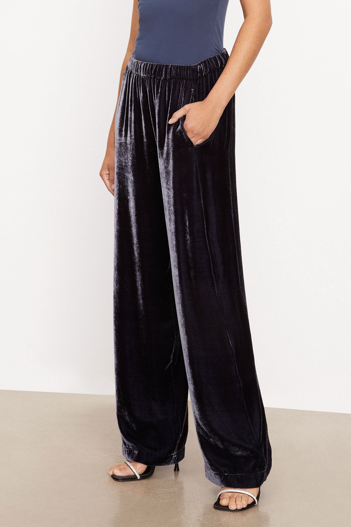   A woman wearing FRIDA SILK VELVET WIDE LEG PANT by Velvet by Graham & Spencer trousers and a blue top. 
