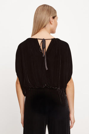 The back view of a woman wearing a NOA SILK VELVET CROPPED TOP with an adjustable tie by Velvet by Graham & Spencer.