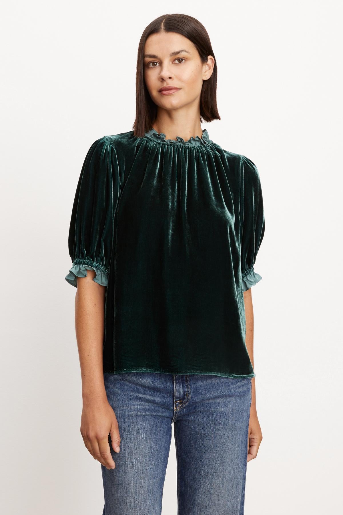 A woman wearing a VAL SILK VELVET TOP by Velvet by Graham & Spencer with elastic ruffle neckline.-35654473154753