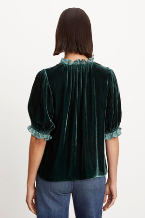 The back view of a woman wearing a Velvet by Graham & Spencer VAL SILK VELVET TOP with elastic ruffle neckline.