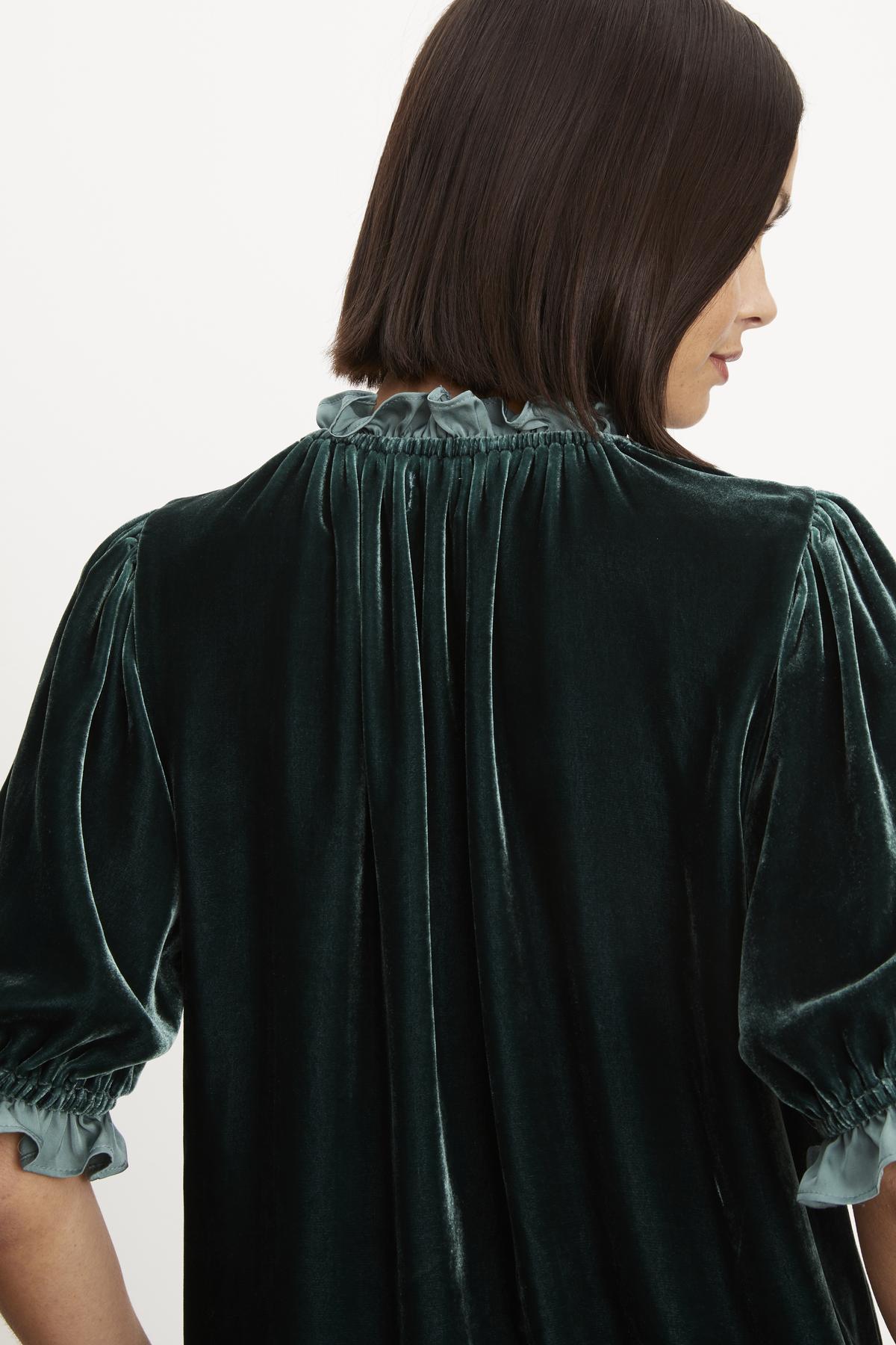   The back view of a woman wearing a VAL SILK VELVET TOP by Velvet by Graham & Spencer that exudes timeless elegance. 