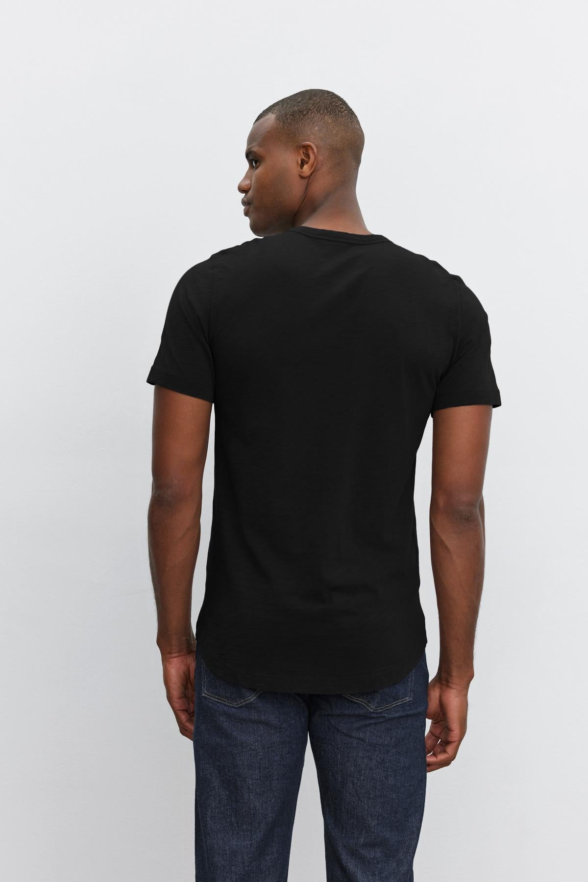  Man wearing a plain black, slub knit Velvet by Graham & Spencer AMARO TEE with a crew neck, viewed from the back. 