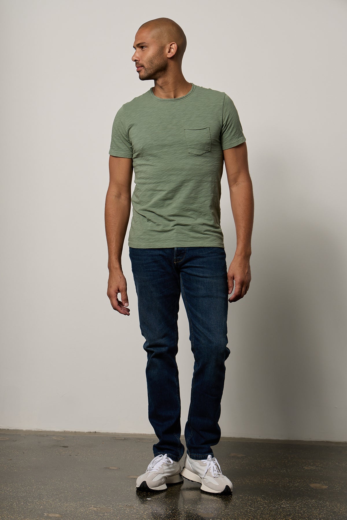   a man wearing jeans and a CHAD RAW EDGE COTTON SLUB POCKET TEE by Velvet by Graham & Spencer. 