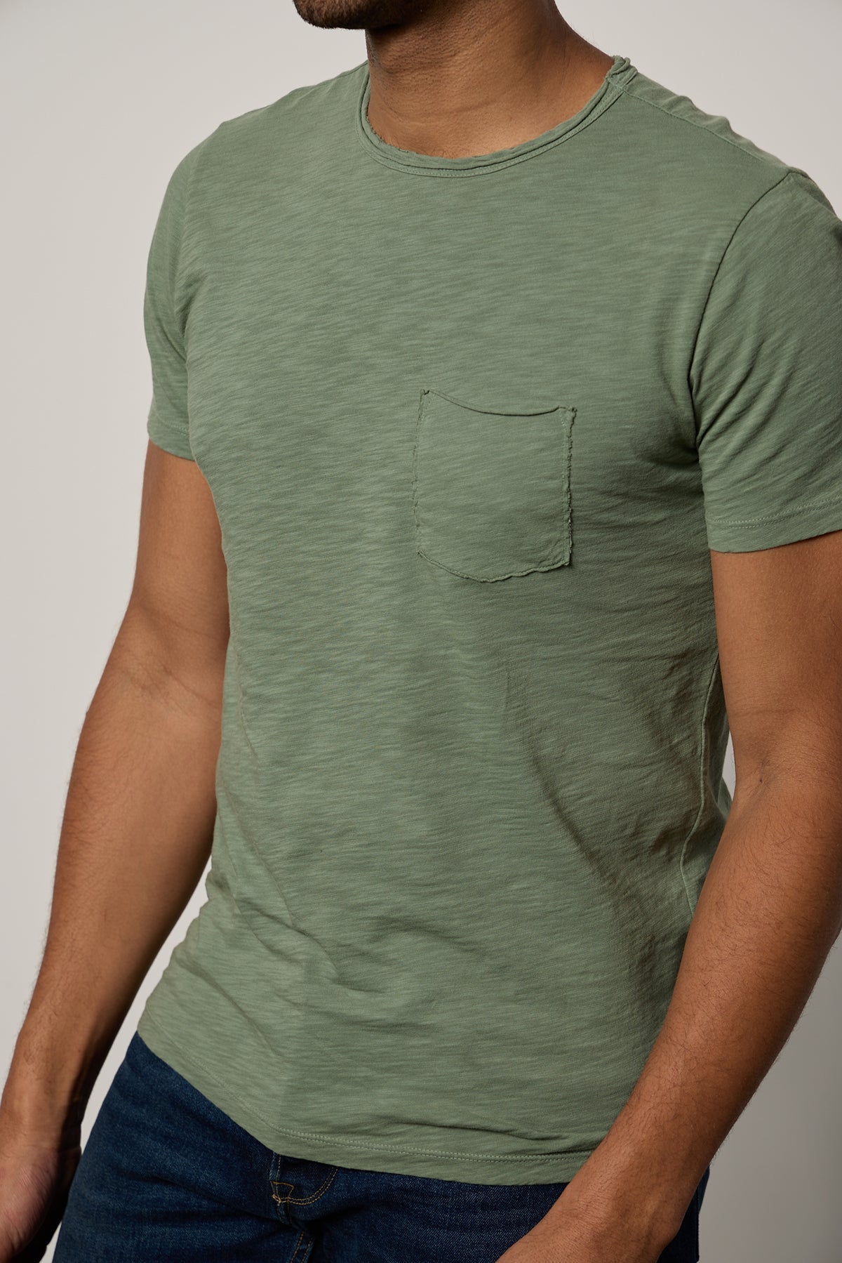   a man wearing a green CHAD RAW EDGE COTTON SLUB POCKET TEE by Velvet by Graham & Spencer. 