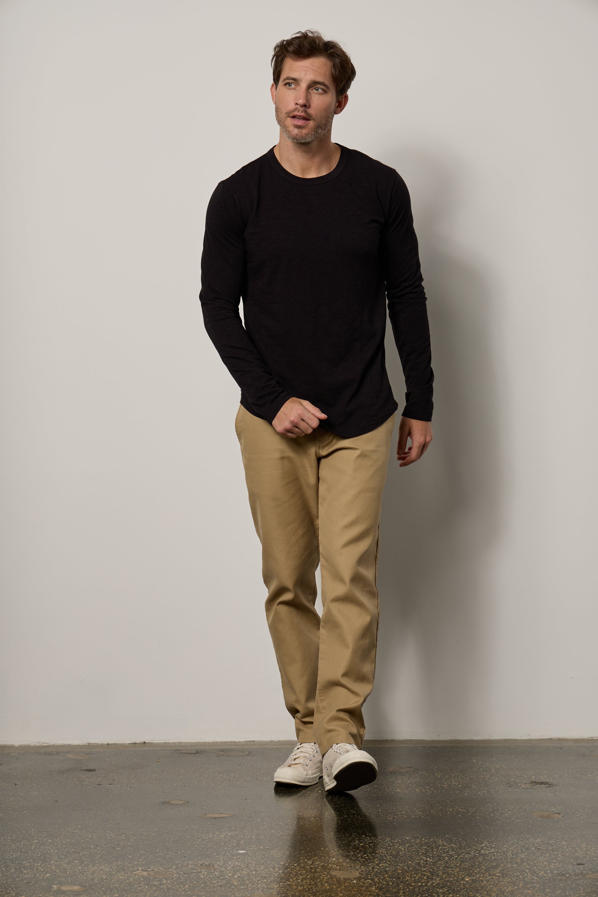   A man in a flawless fit, wearing a Velvet by Graham & Spencer KAI CREW NECK TEE and khaki pants. 