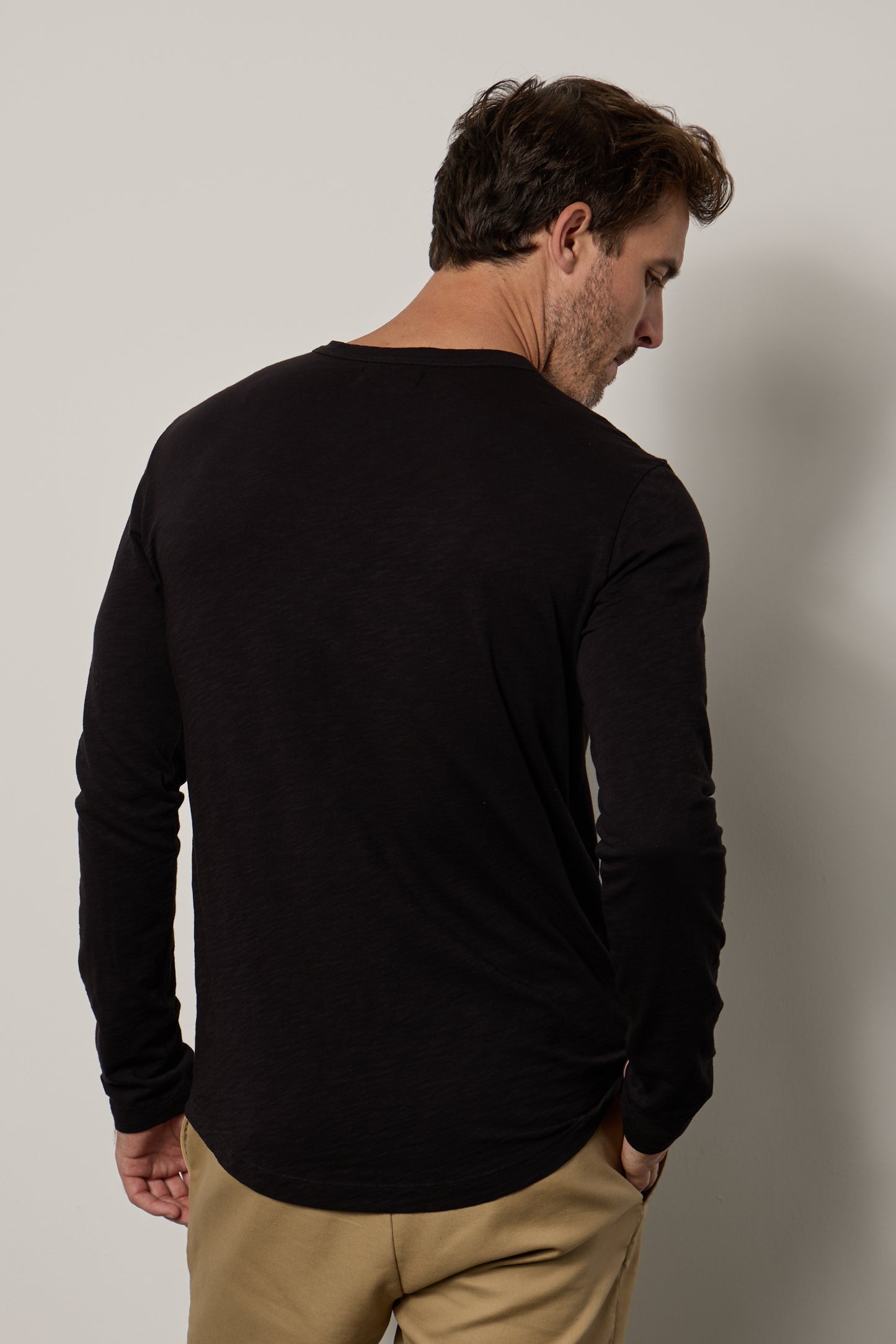 The back of a man wearing a Velvet by Graham & Spencer KAI CREW NECK TEE and khaki pants.-35607579164865