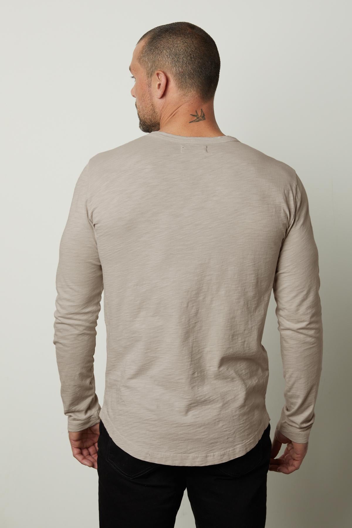 The back view of a man wearing a Velvet by Graham & Spencer KAI CREW NECK TEE, perfect for layering.-35776214663361