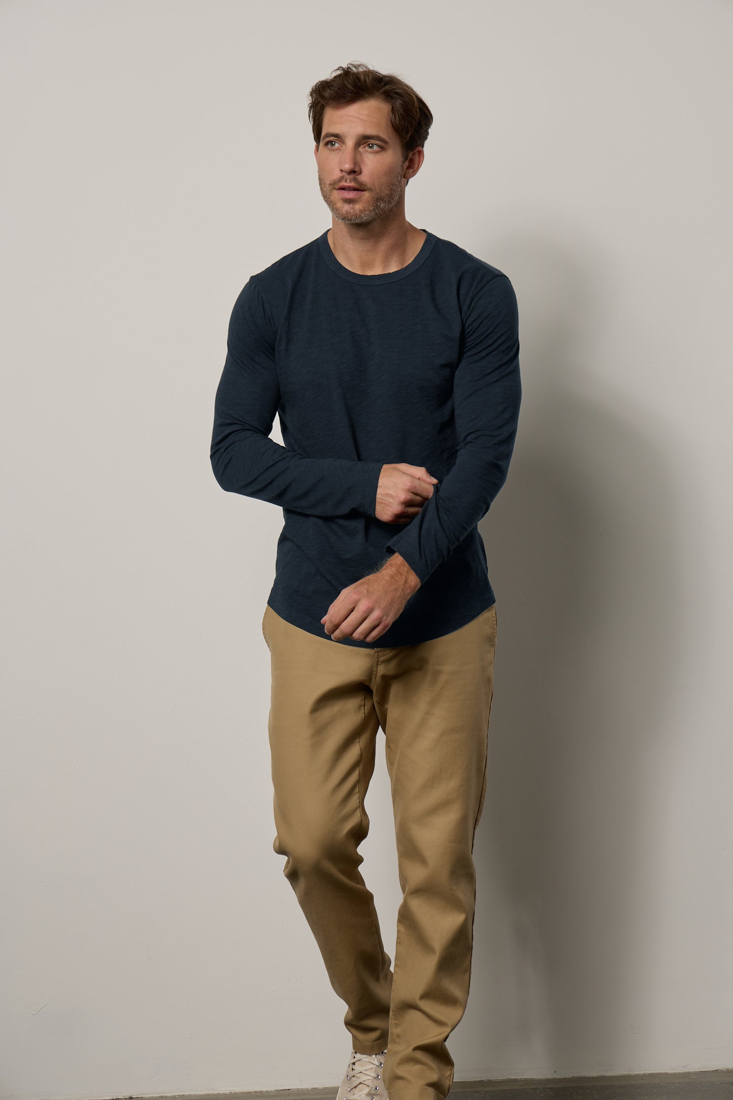 A man wearing a Velvet by Graham & Spencer KAI CREW NECK TEE in navy and khaki pants rocked a flawless fit.-35607579230401