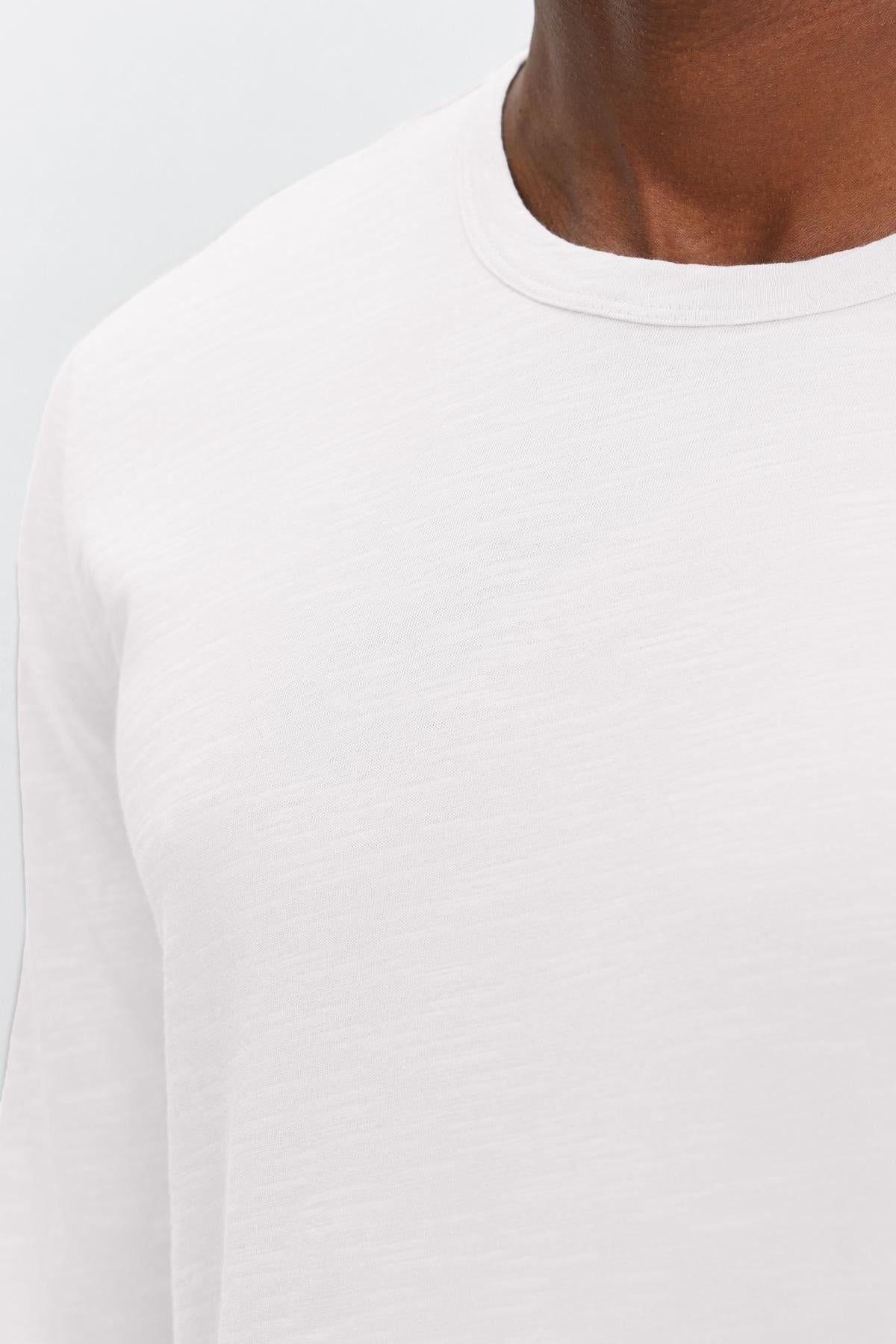   Close-up of a man wearing a Velvet by Graham & Spencer KAI CREW NECK TEE, focusing on the shoulder and neck area against a light background. 