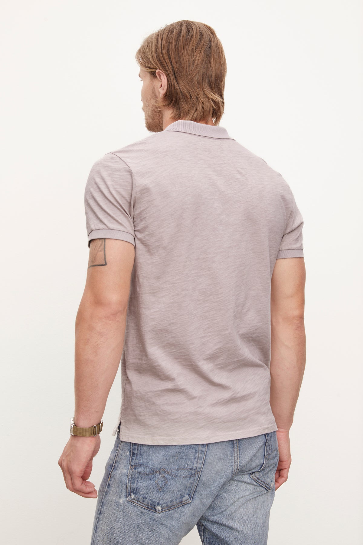   The back of a man wearing jeans and a Velvet by Graham & Spencer NIKO POLO made of soft cotton slub. 