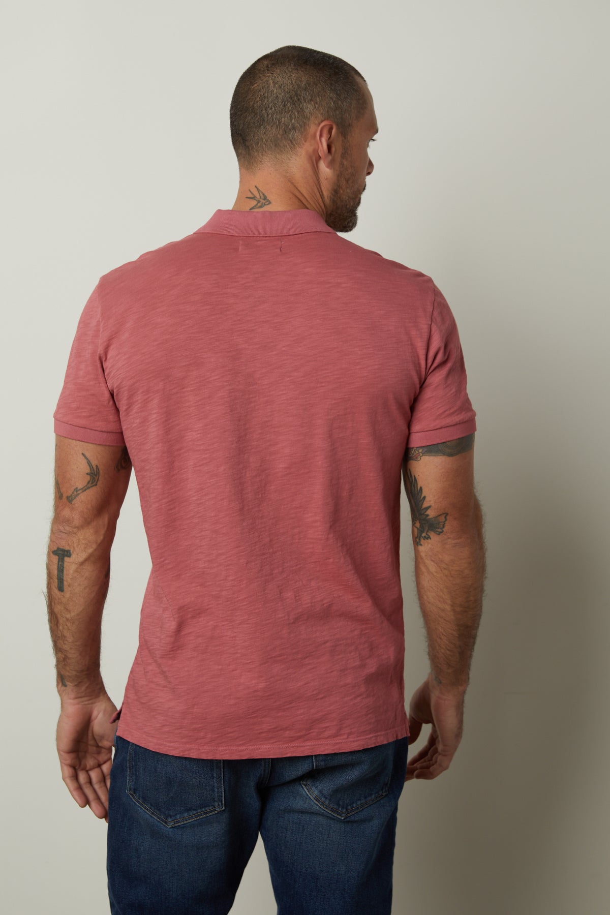   The back view of a man wearing a NIKO POLO shirt by Velvet by Graham & Spencer. 