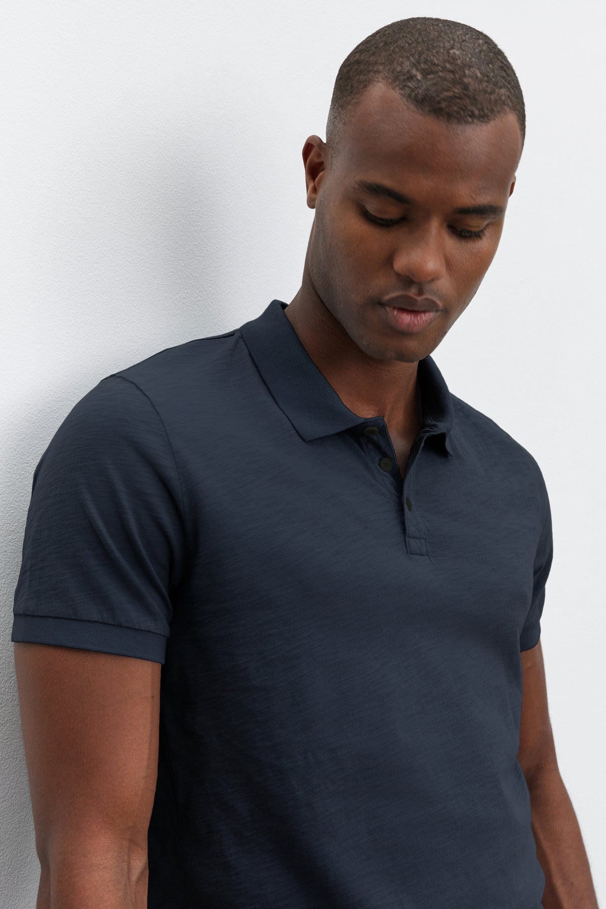 A man wearing a Velvet by Graham & Spencer NIKO POLO shirt with a heathered texture, standing with his eyes closed against a white background.-36890752712897