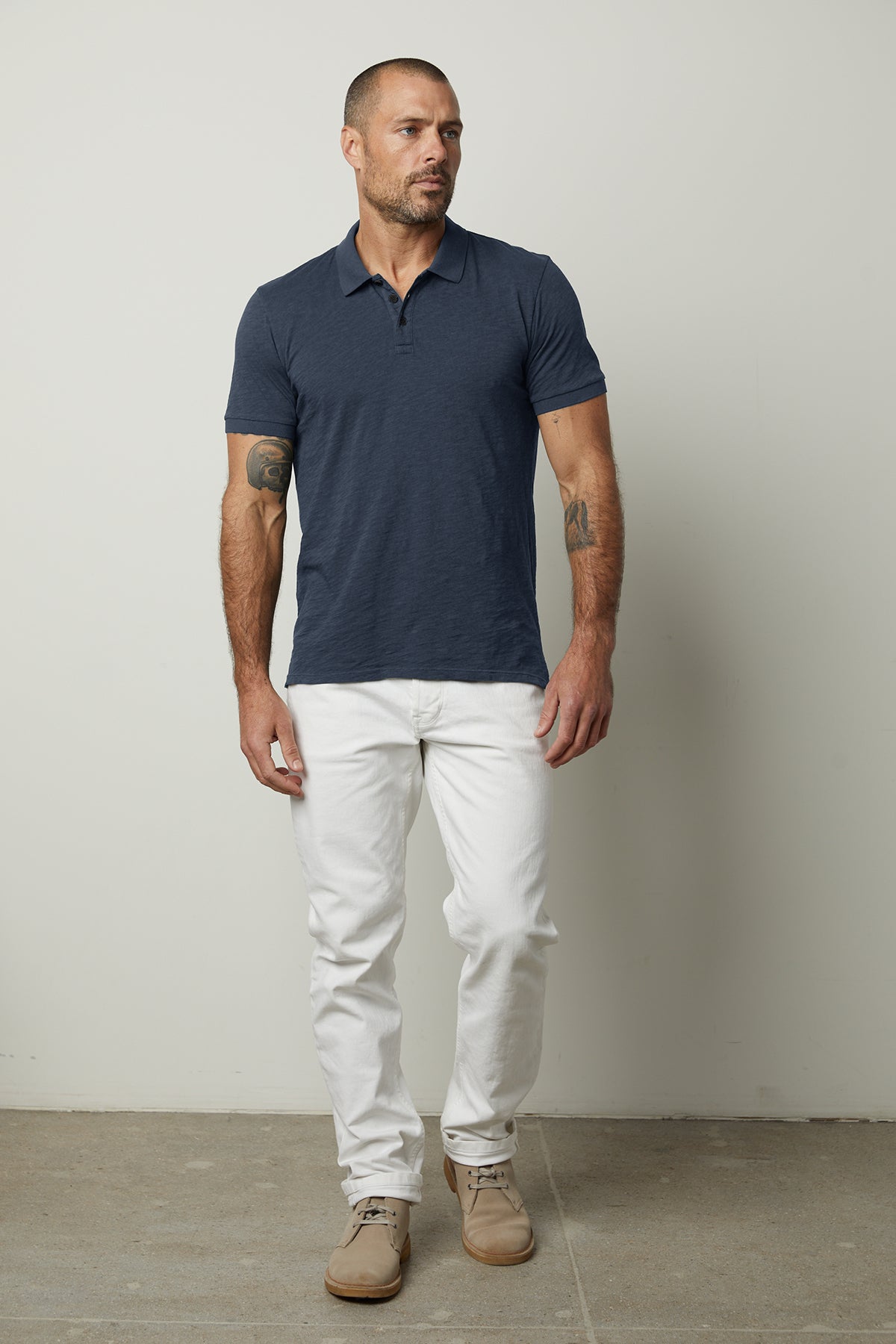A man wearing a NIKO POLO shirt by Velvet by Graham & Spencer and white pants.-26705928552641