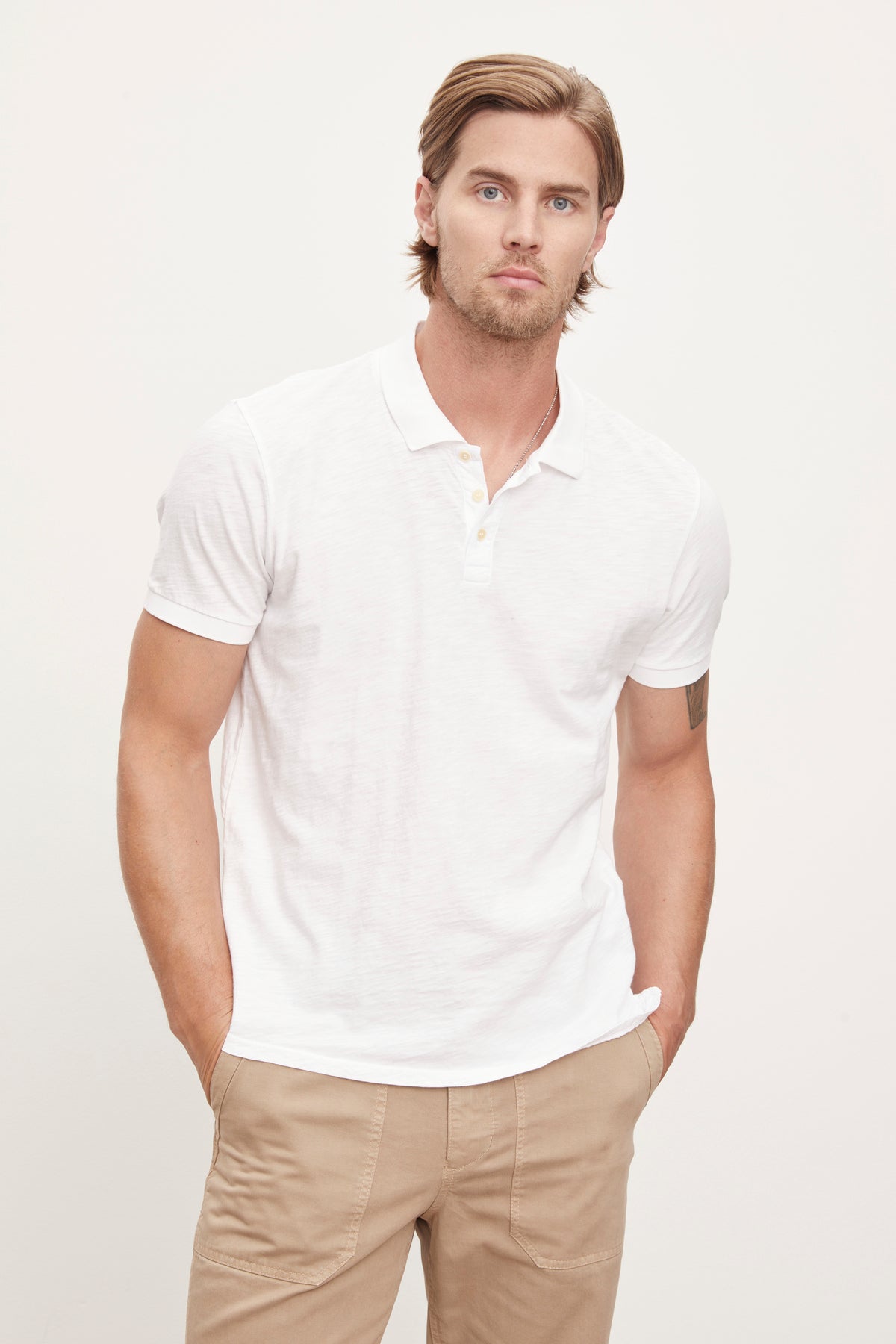   The model is wearing a white NIKO POLO shirt by Velvet by Graham & Spencer with a vintage-feel. 