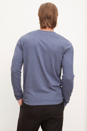 The back view of a man wearing a Velvet by Graham & Spencer SIMEON raw-edge cotton slub tee in blue, embodying California heritage.