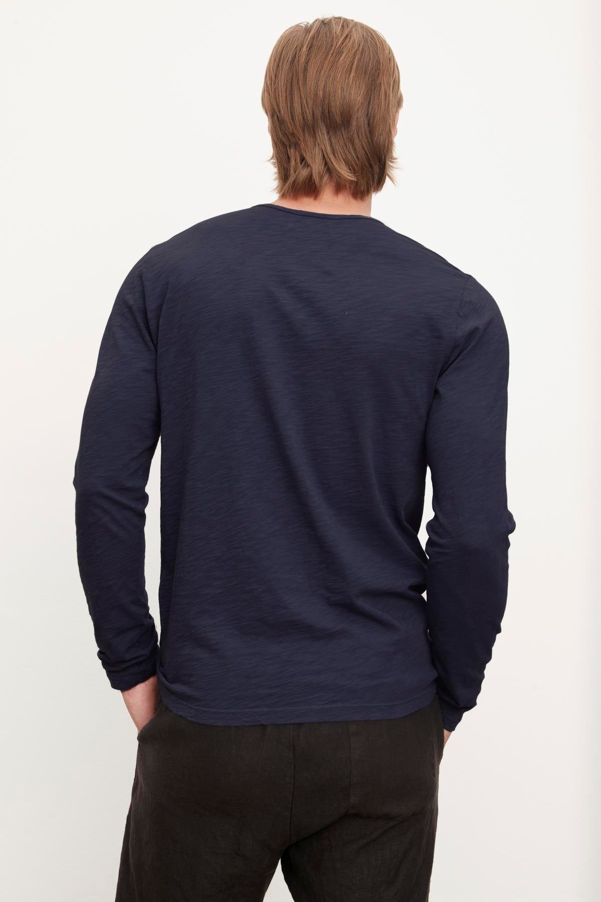 Man standing with his back to the camera wearing a Velvet by Graham & Spencer SIMEON RAW EDGE COTTON SLUB TEE.-36418292220097