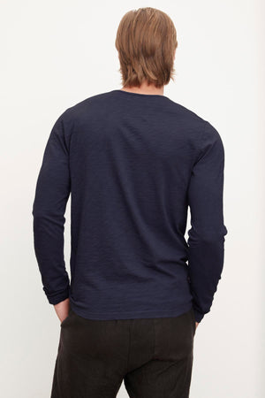 Man standing with his back to the camera wearing a Velvet by Graham & Spencer SIMEON RAW EDGE COTTON SLUB TEE.