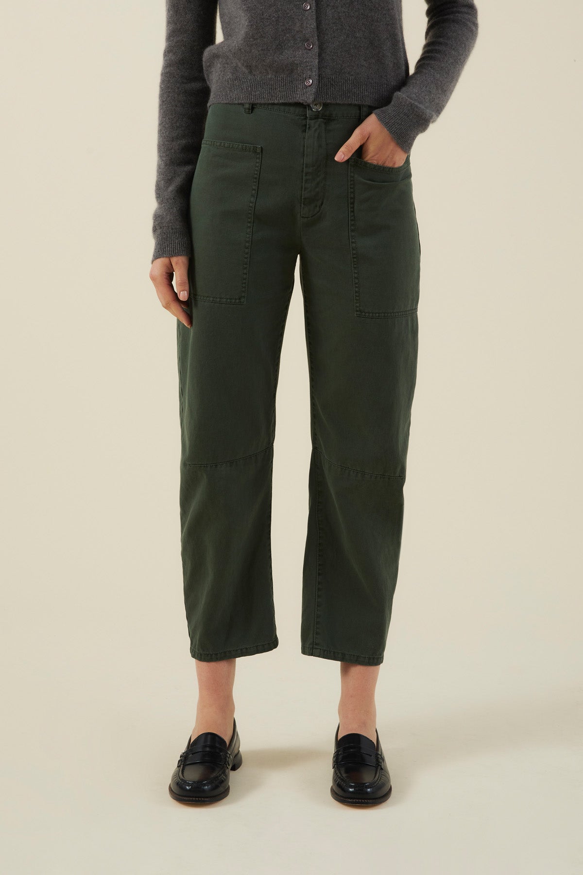 Velvet by Graham & Spencer BRYLIE PANT in dark green with a barrel leg and utilitarian patch pockets, worn with a grey cardigan and black loafers.-46488162173121