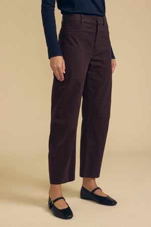 Dark brown cotton twill BRYLIE PANT trousers with utilitarian patch pockets, worn with a dark long-sleeved top and black Mary Jane flats.