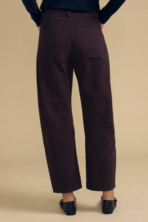 Back view of dark brown high-waisted BRYLIE PANT barrel leg pants featuring utilitarian patch pockets and knee seam detailing.