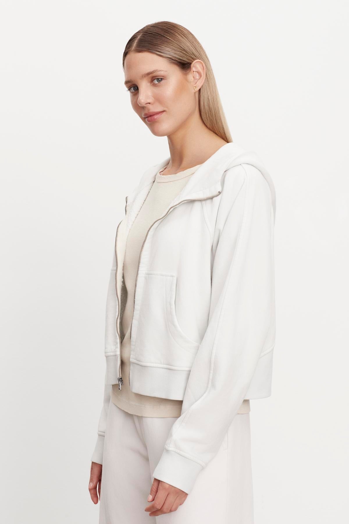   The model is wearing a white TORY SOFT FLEECE HOODIE jacket and pants. (Brand name: Velvet by Graham & Spencer) 