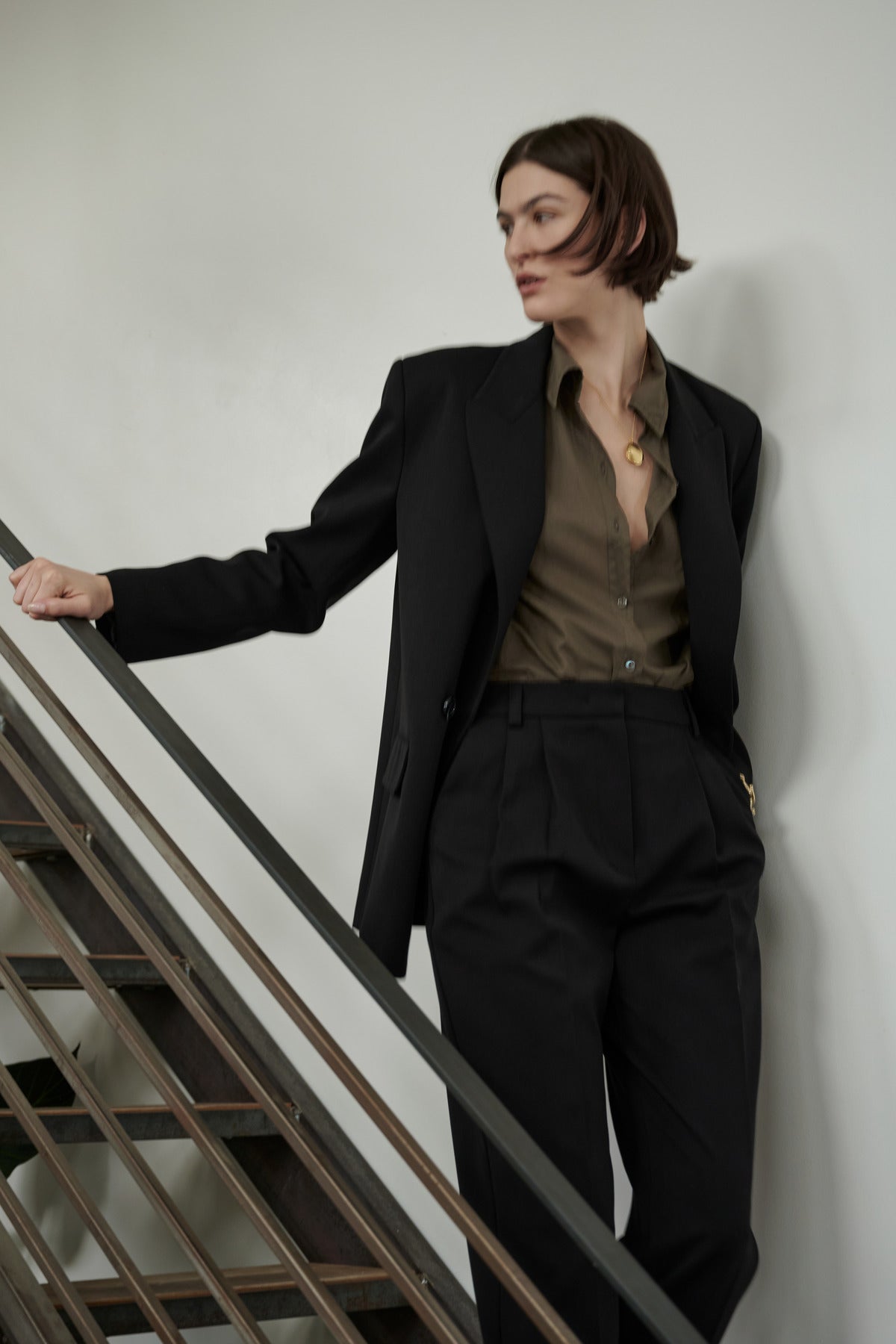   A person in a Velvet by Jenny Graham REDONDO BUTTON-UP SHIRT silhouette leaning on a staircase. 