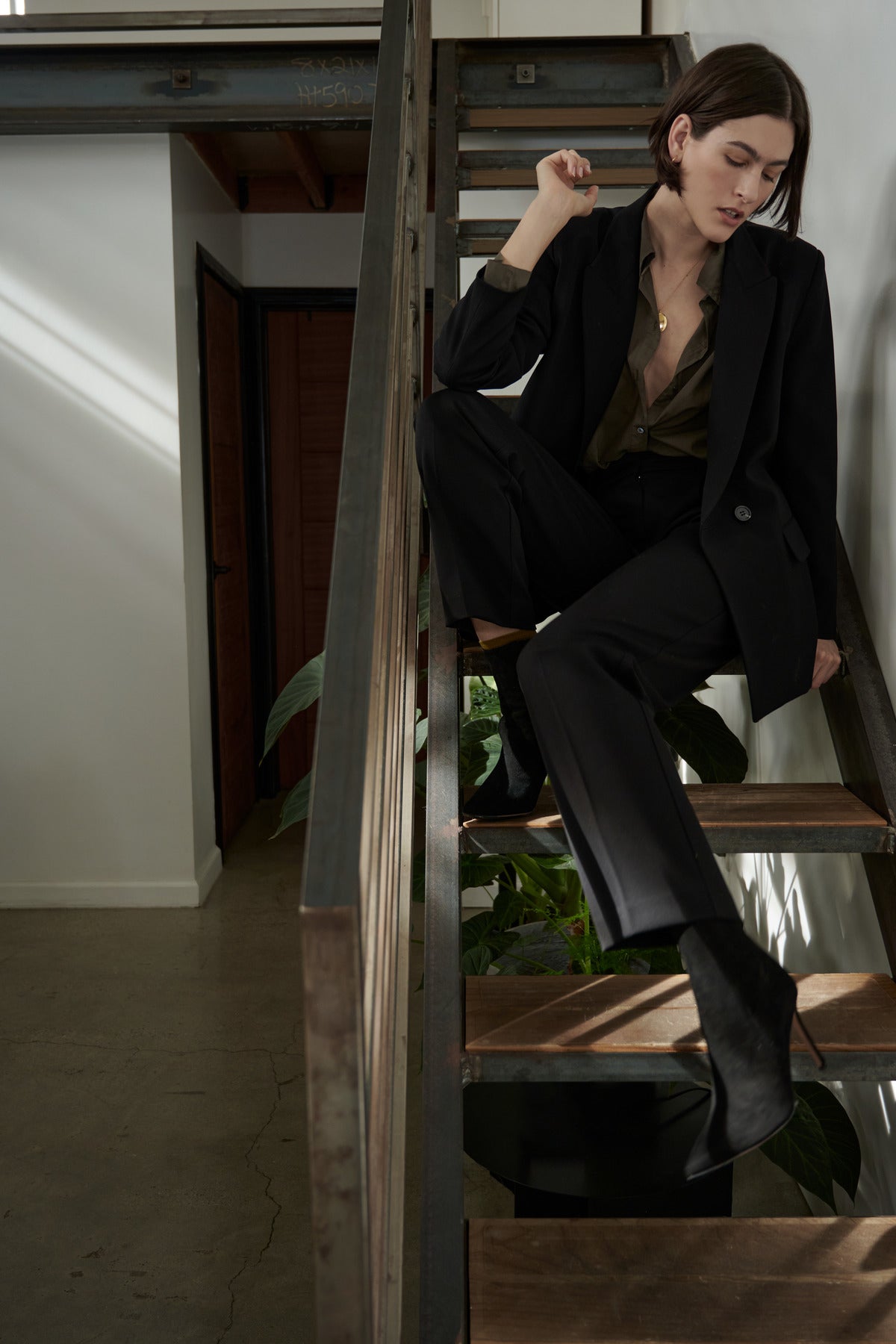 A woman sitting on a staircase in a Velvet by Jenny Graham BUNDY PANT suit.-26827819974849