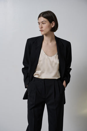 A woman wearing a black blazer and a white Velvet by Jenny Graham NOLITA TANK TOP blouse.
