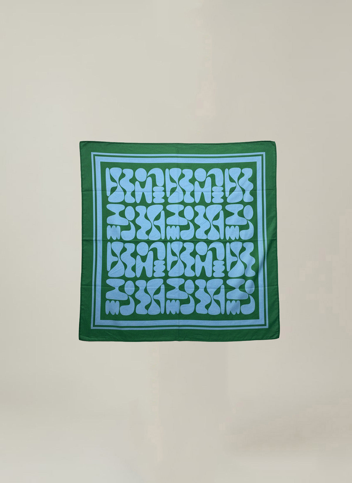 The SOLI SCARF by Velvet by Graham & Spencer is a square green printed cotton scarf with a blue geometric pattern, abstract shapes, and a blue border—a versatile accessory for any wardrobe.-41645107019969