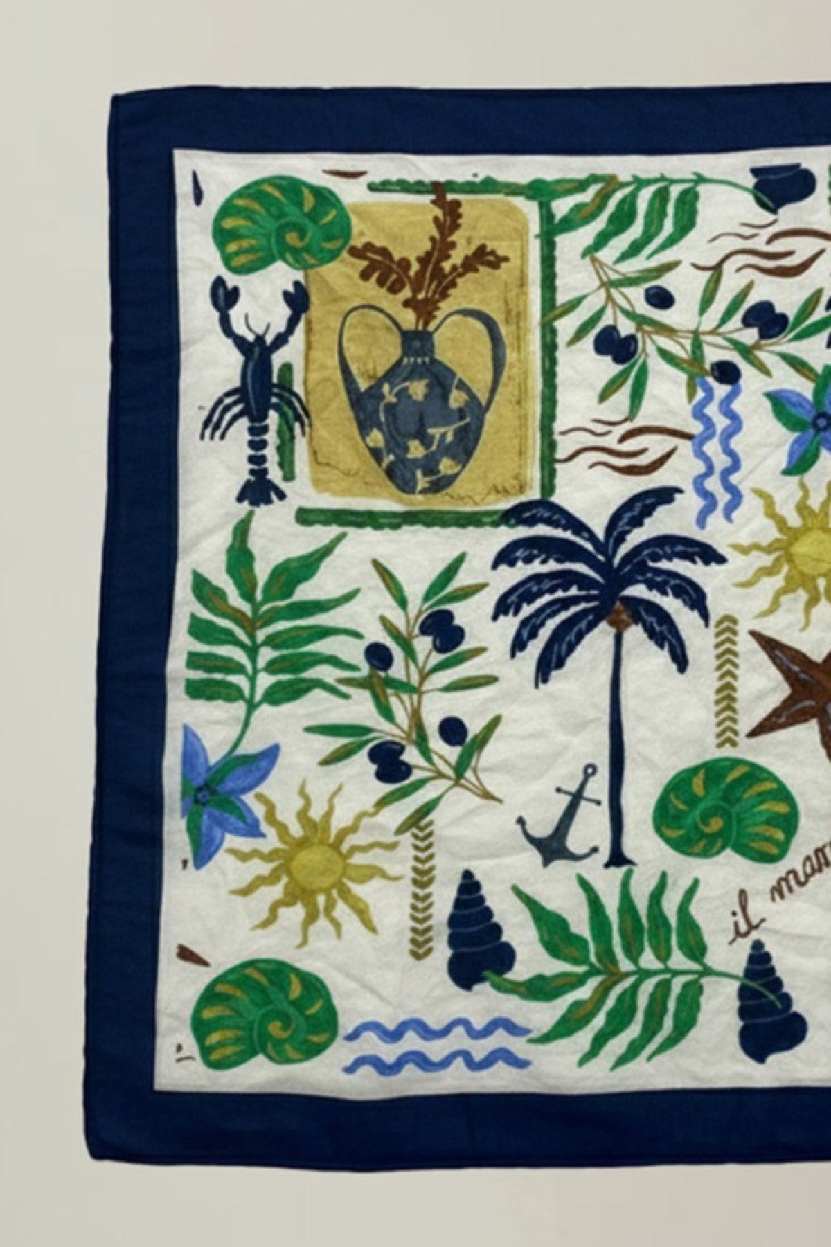 The SOLI SCARF by Velvet by Graham & Spencer is a versatile square accessory with a navy border, embroidered with a vase, palm tree, plants, sun, lobster, anchor, seashells, and the phrase "il mare.-41527515087041