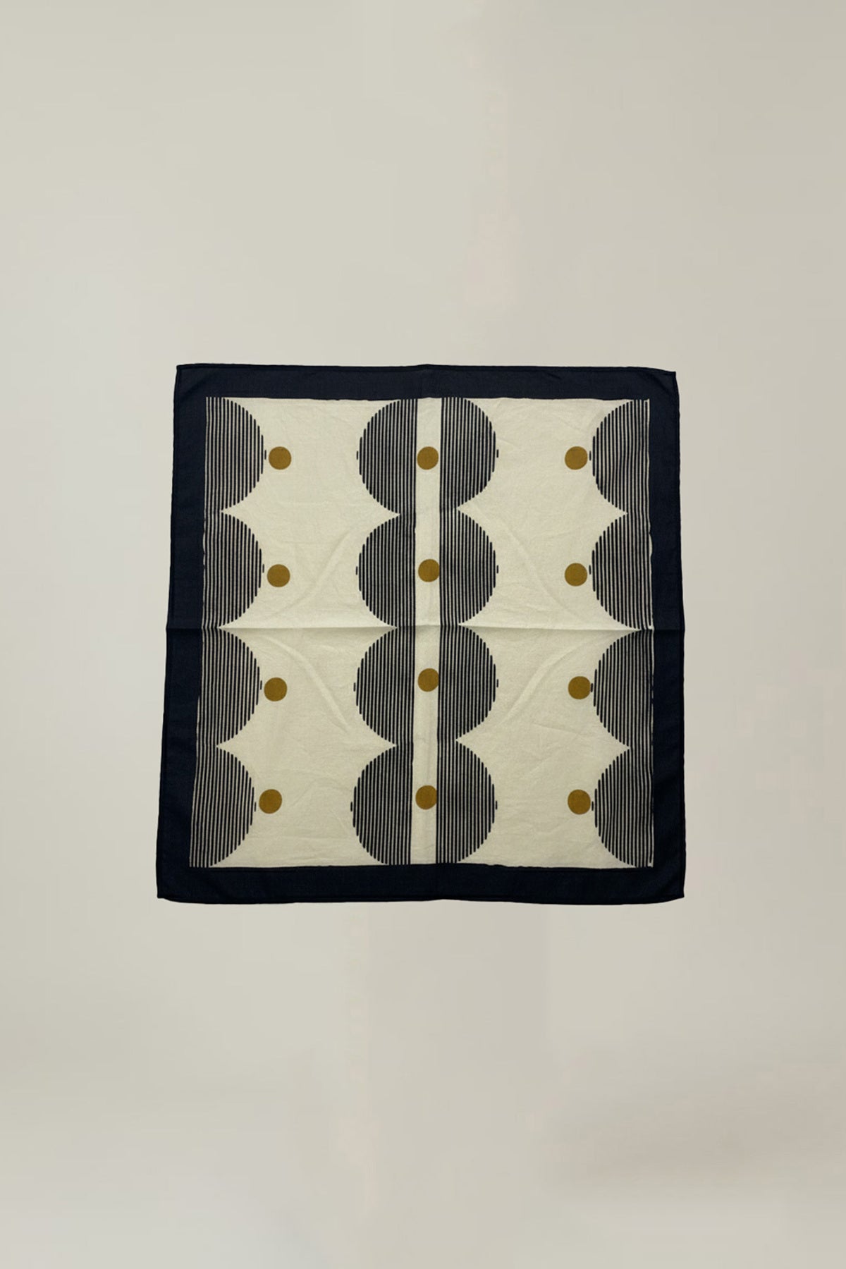 The SOLI SCARF by Velvet by Graham & Spencer is a square fabric with a black border, adorned with black stripes, white zigzag shapes, and gold dots on a light background.