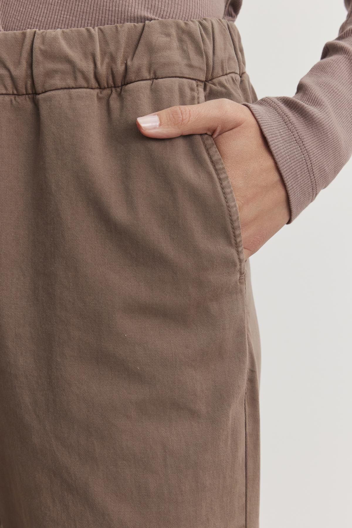   The NAYA PANT by Velvet by Graham & Spencer allows a person's hand to rest comfortably in the pocket of wide-leg pants, crafted from soft stretch cotton twill. 