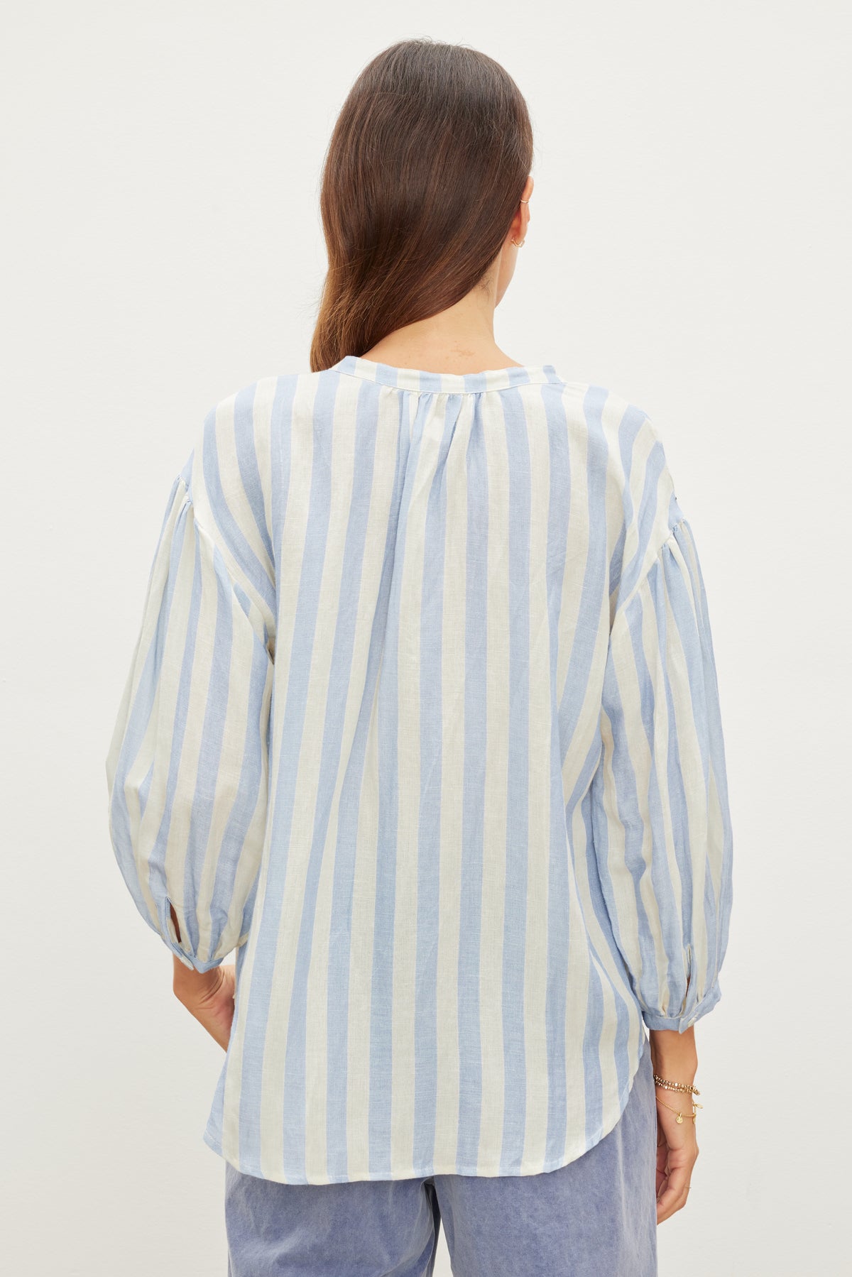   A woman seen from behind wearing a Velvet by Graham & Spencer Gabby Striped Linen Top with puffed sleeves. 