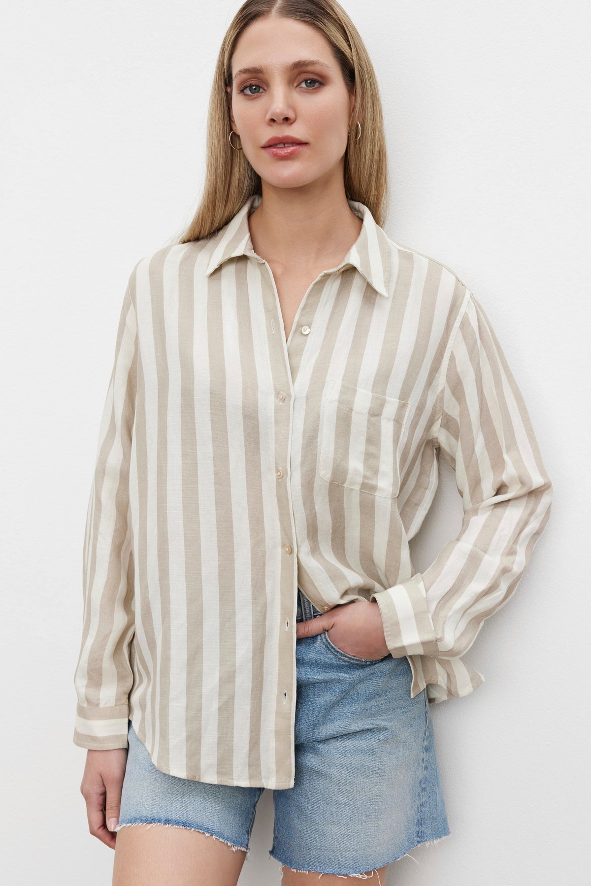 The model is wearing a white HARLOW STRIPED LINEN BUTTON-UP SHIRT by Velvet by Graham & Spencer.-36247888036033