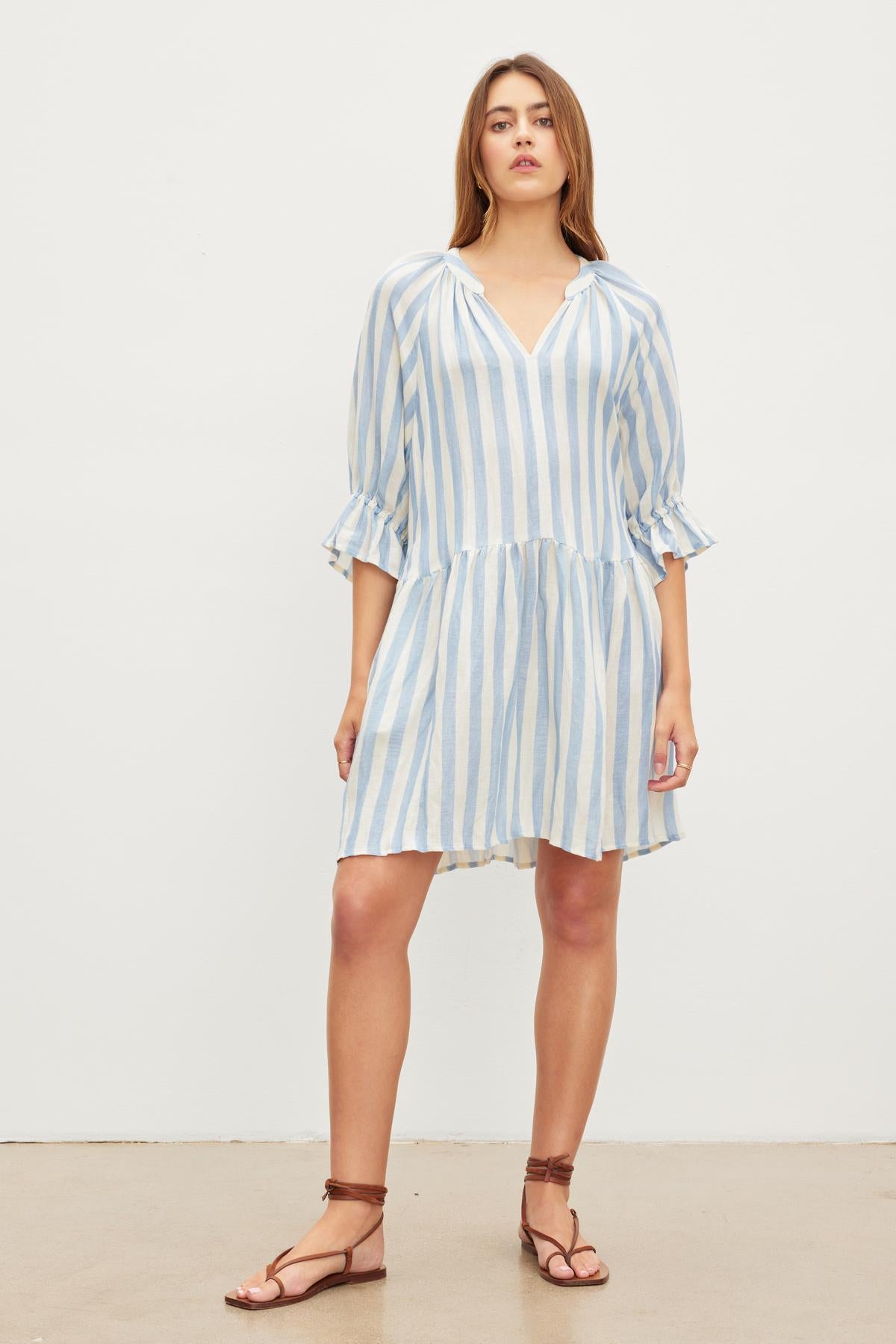 Woman in a Velvet by Graham & Spencer JESSICA STRIPED LINEN DRESS standing against a plain background.-36580699537601