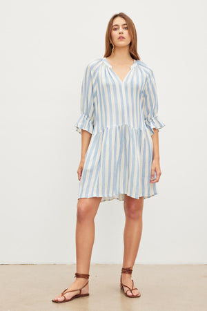 Woman in a Velvet by Graham & Spencer JESSICA STRIPED LINEN DRESS standing against a plain background.