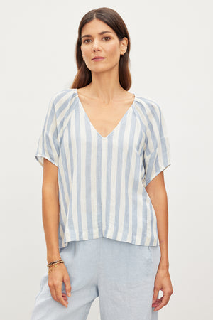 A woman in a relaxed fit Katy Striped Linen Top, exuding Velvet by Graham & Spencer vibes.
