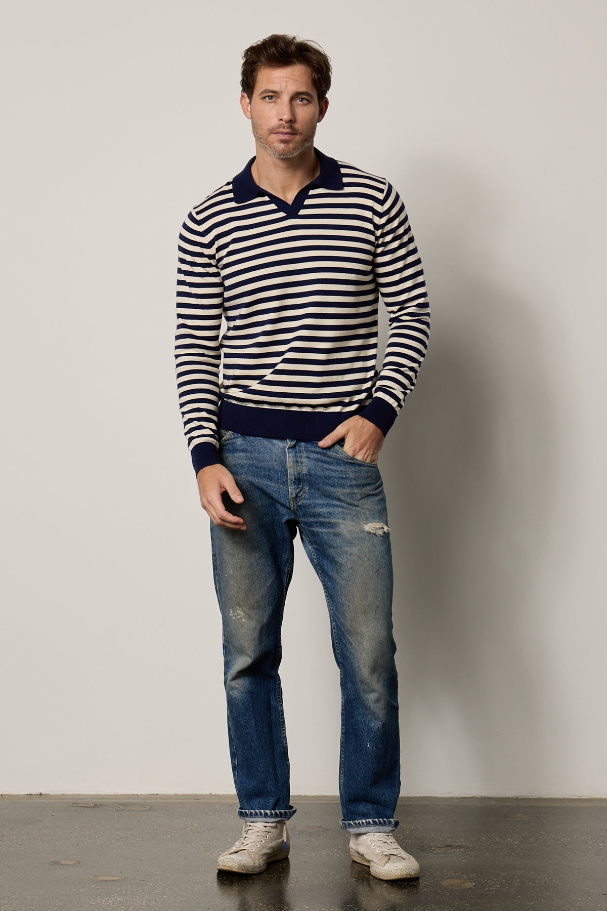 a man wearing the Velvet by Graham & Spencer Ricky Striped Polo and jeans.-26496382337217