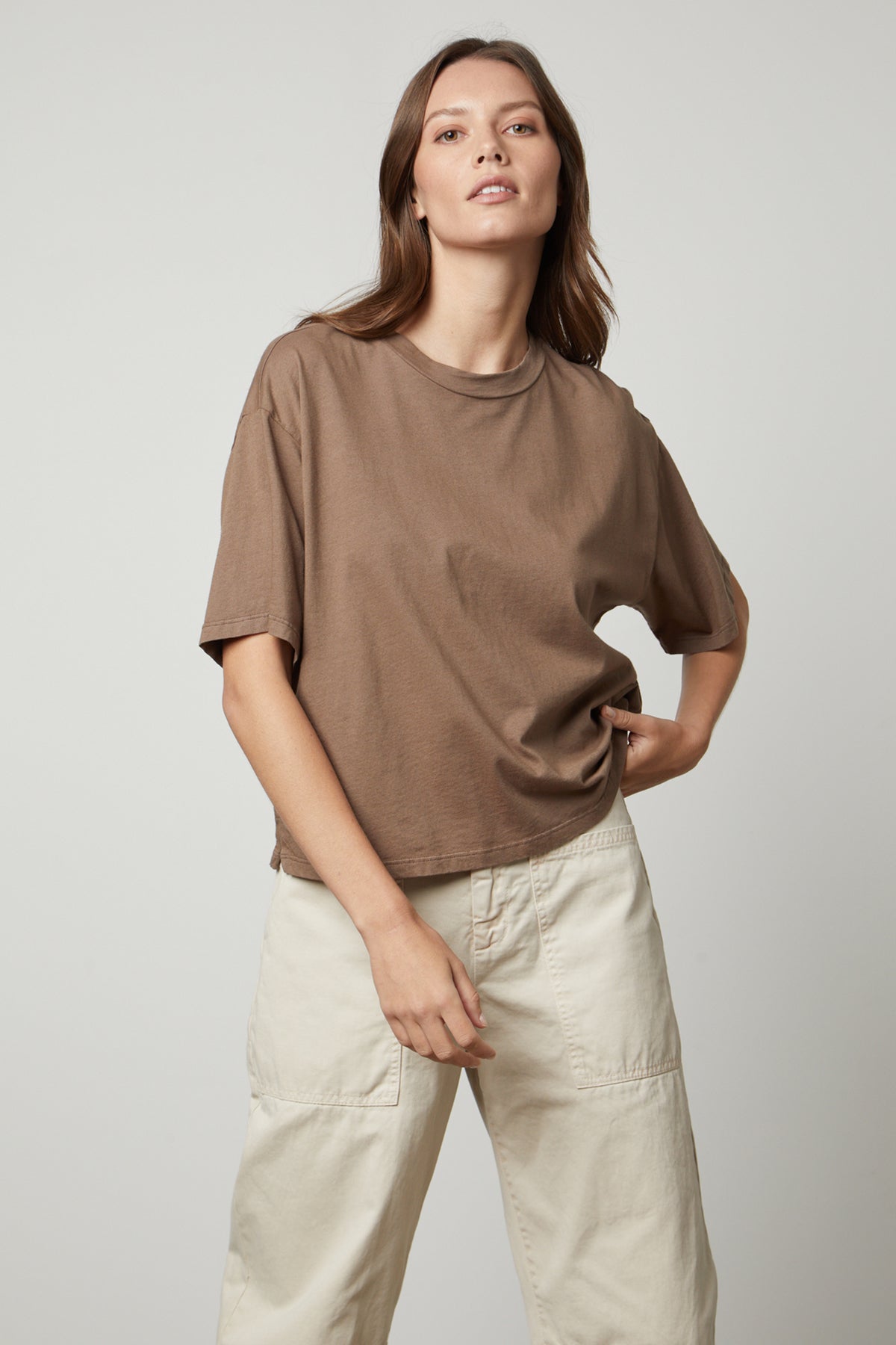 The model is wearing a Velvet by Graham & Spencer oversized fit brown CLARAH CREW NECK TEE shirt and beige pants, styled with sueded jersey fabric.-35655921107137