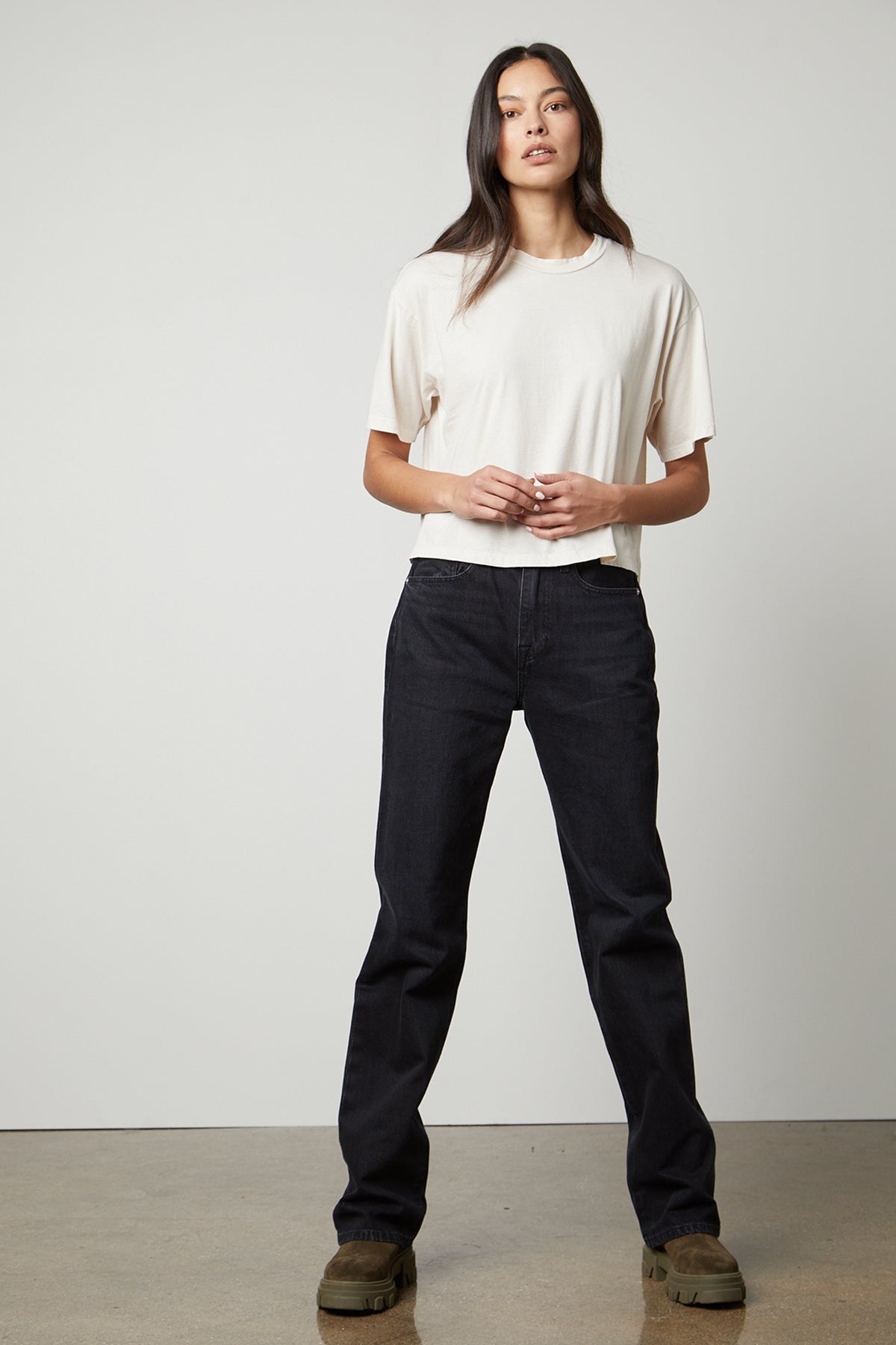 A woman wearing black jeans and a Velvet by Graham & Spencer CLARAH CREW NECK TEE.-26799861924033