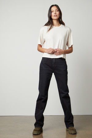 A woman wearing black jeans and a Velvet by Graham & Spencer CLARAH CREW NECK TEE.