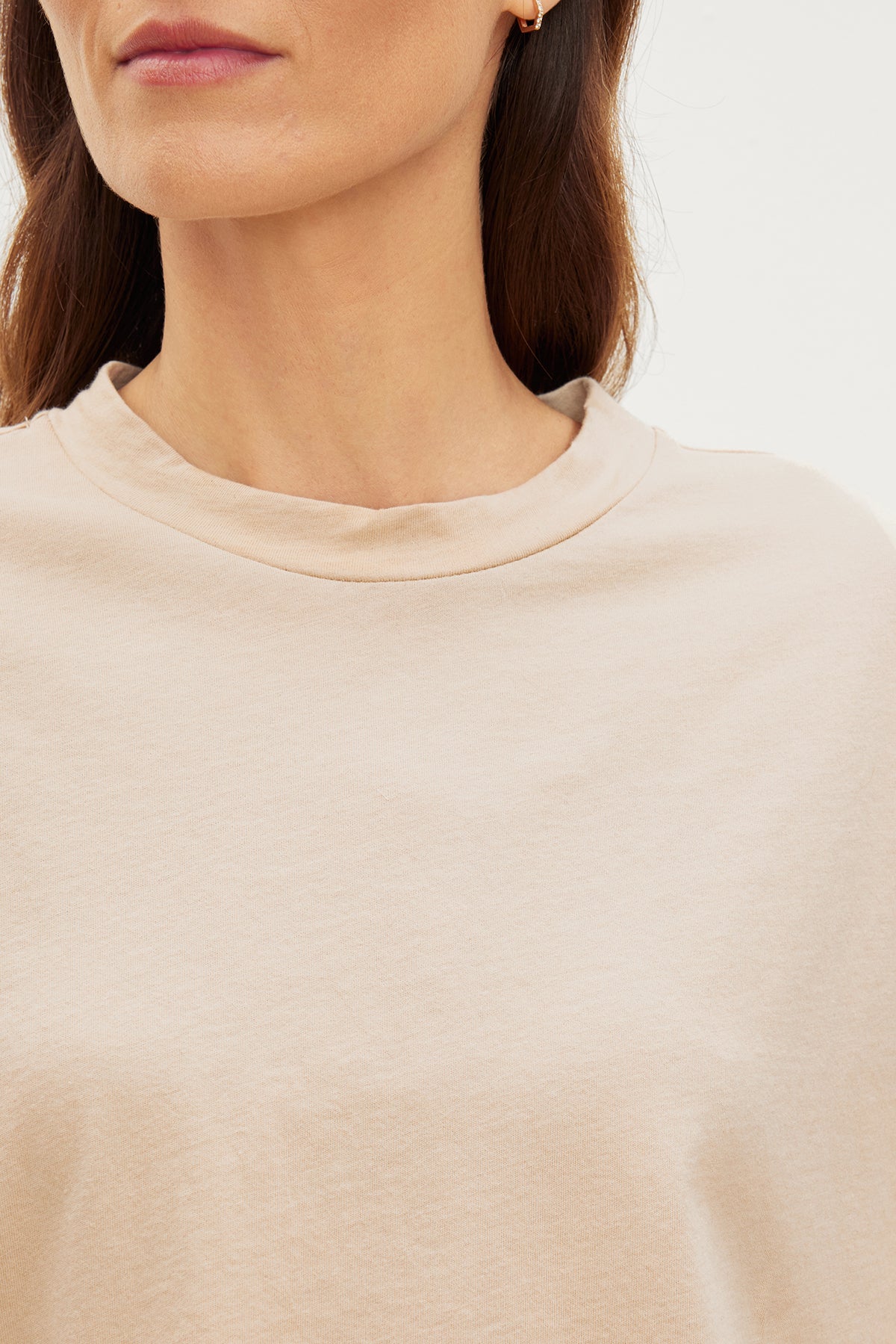   A woman styling a relaxed beige CLARAH CREW NECK TEE made of sueded jersey fabric by Velvet by Graham & Spencer. 