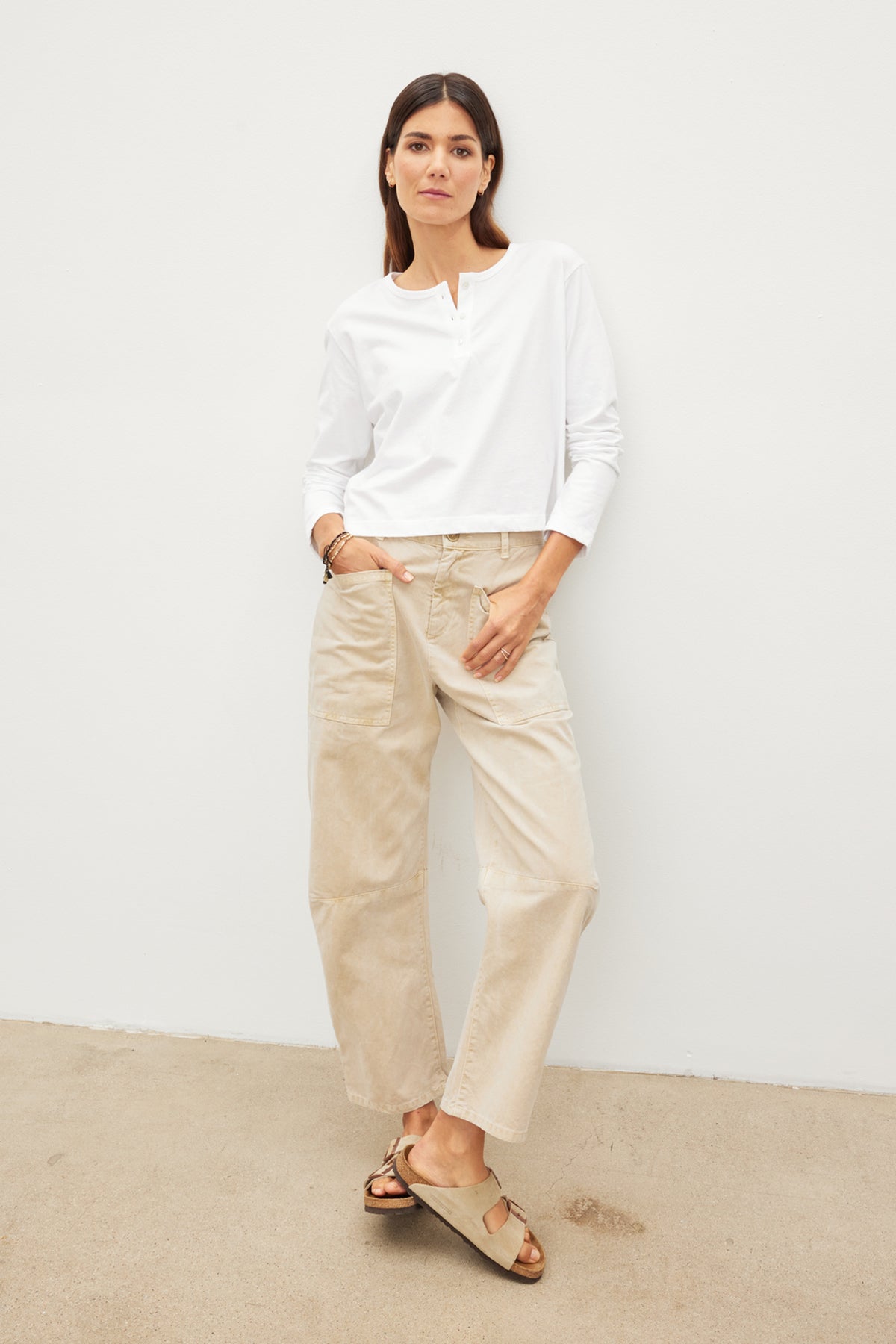   A woman wearing a white shirt and Velvet by Graham & Spencer's BRYLIE SANDED TWILL UTILITY PANT. 