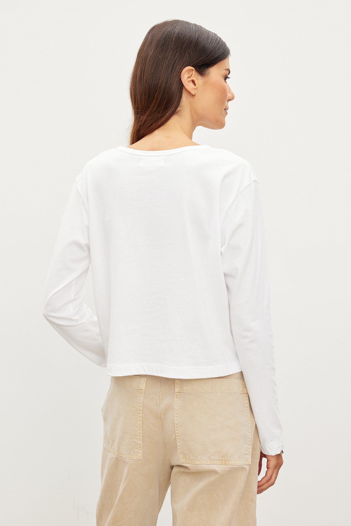 A woman in a white shirt, featuring the DELIAH CROPPED HENLEY by Velvet by Graham & Spencer - perfect for an everyday wardrobe.-35955698139329