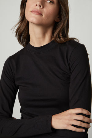 The model is wearing a Velvet by Graham & Spencer LINNY MOCK NECK TEE.