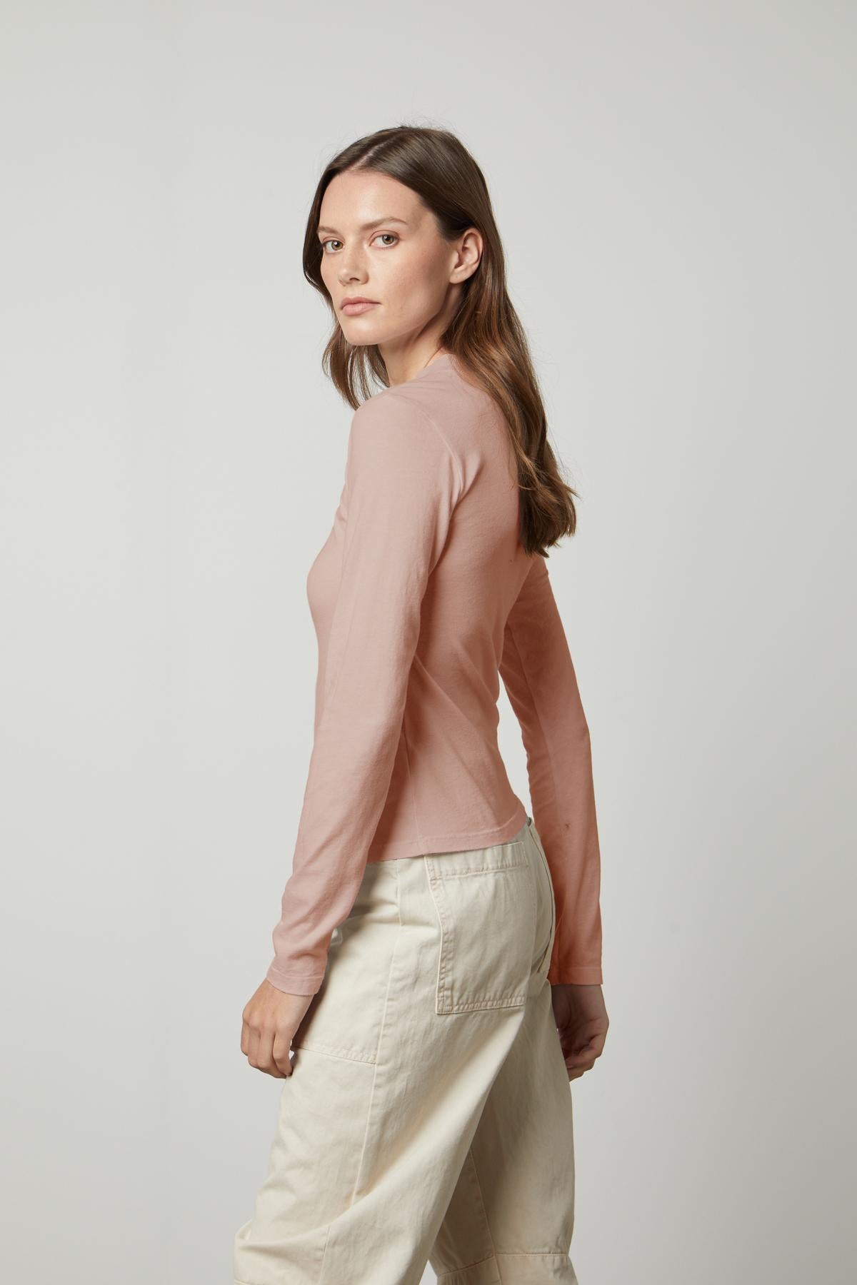   The model is wearing a LINNY MOCK NECK TEE by Velvet by Graham & Spencer, creating a flattering silhouette. 