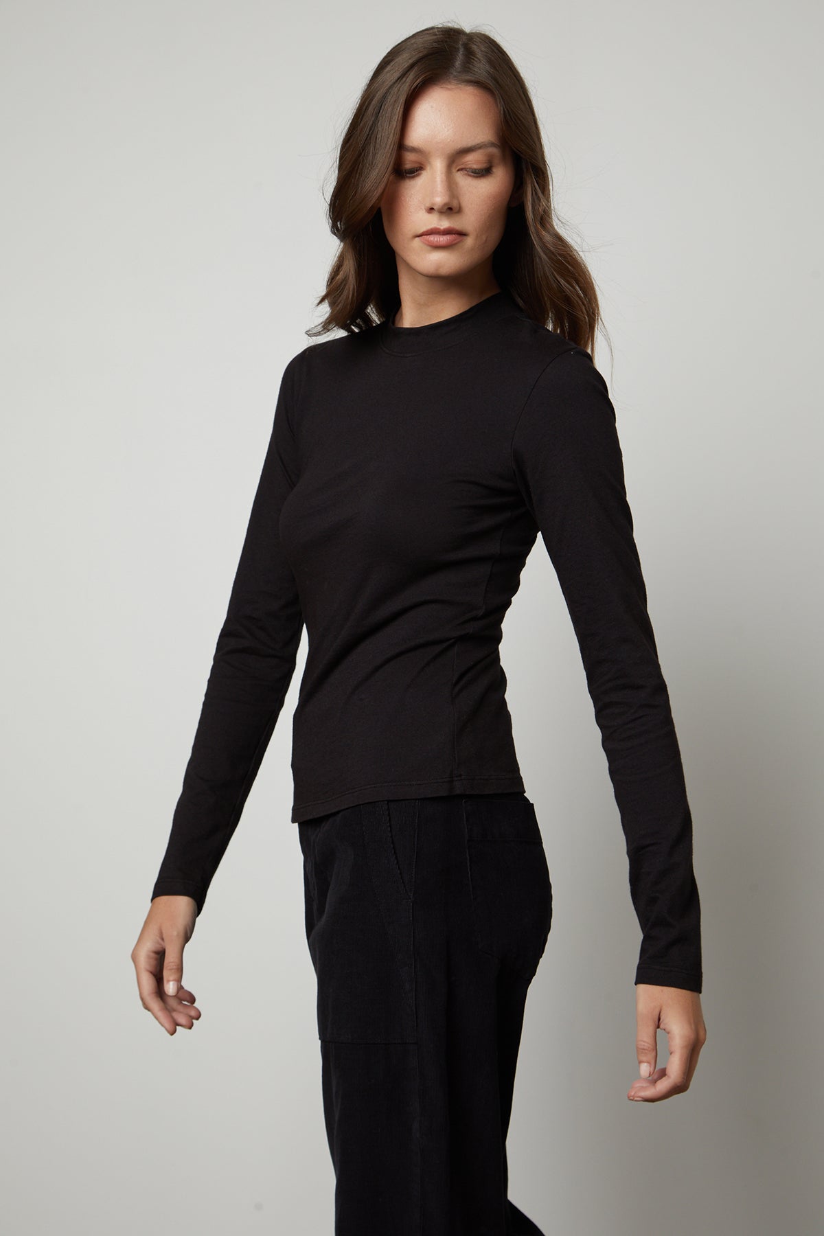   The model is wearing a LINNY MOCK NECK TEE by Velvet by Graham & Spencer. 