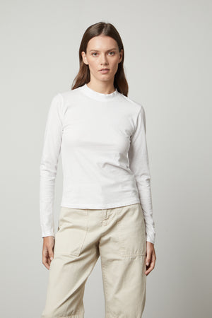 The LINNY MOCK NECK TEE by Velvet by Graham & Spencer is wearing a white long-sleeved tee.